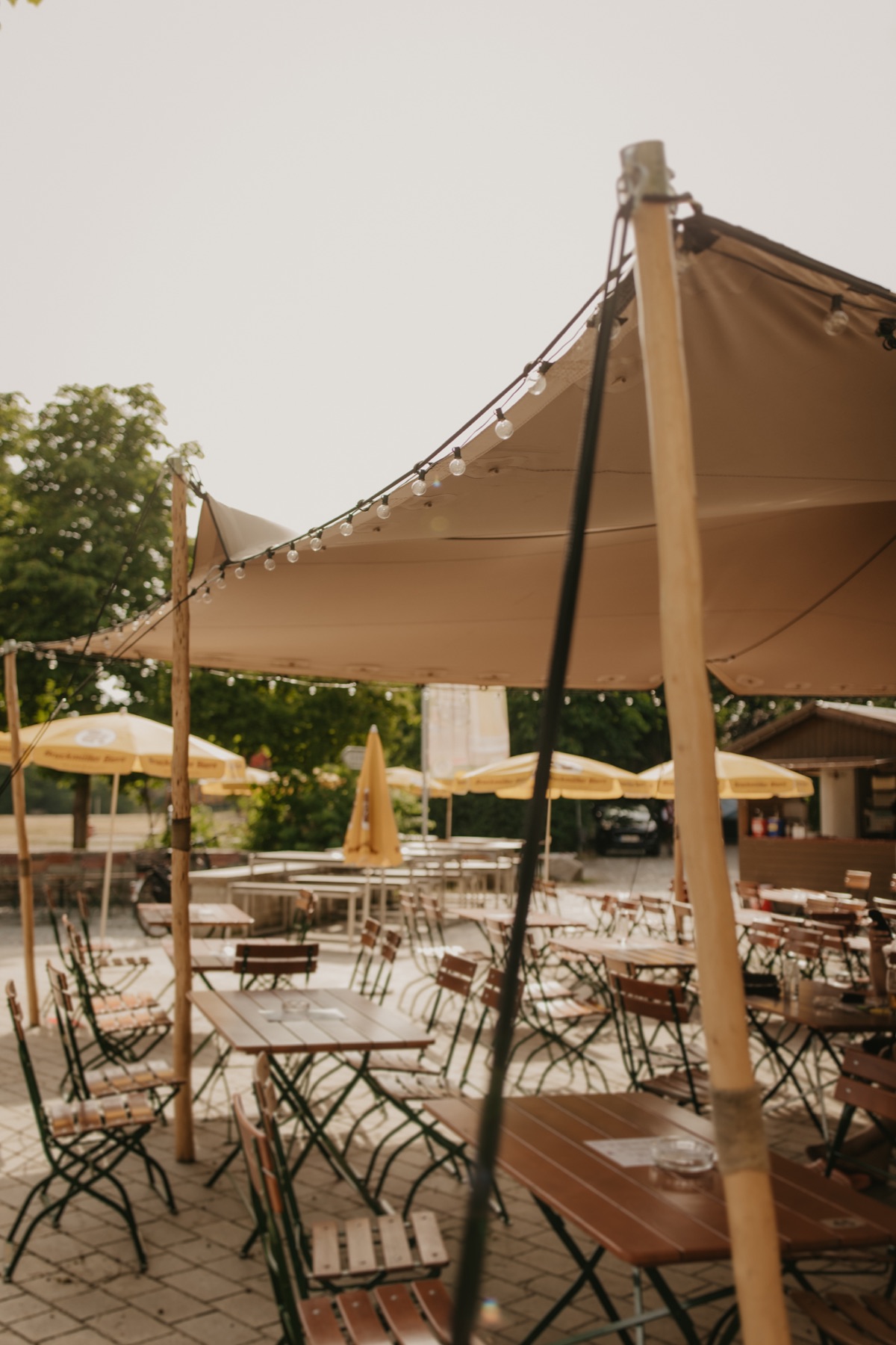 Sitzplätze und Lichterketten im Biergarten im Stadtpark